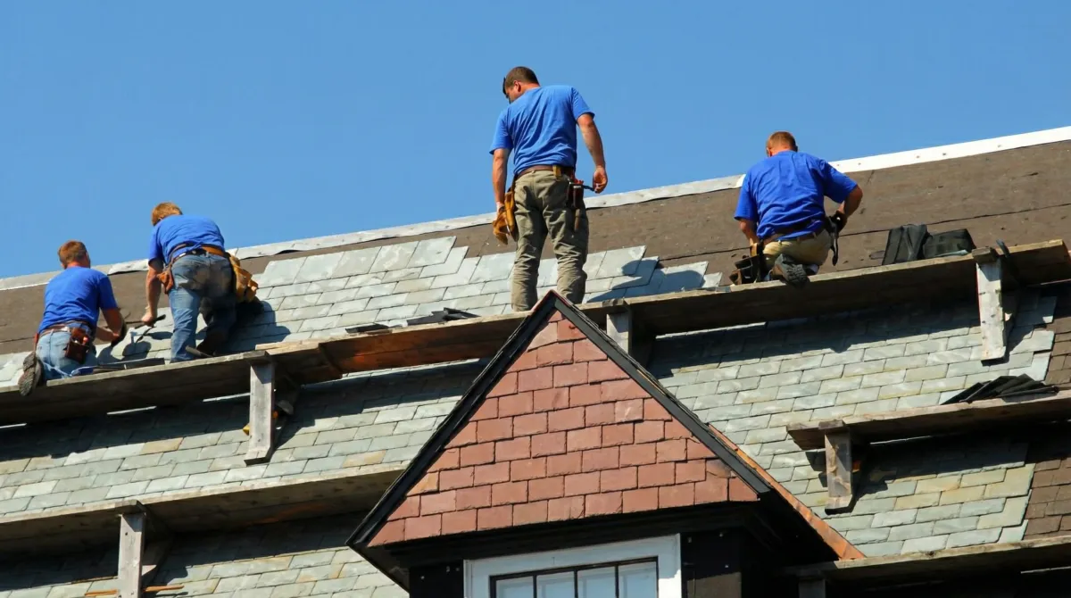 Roof replacement in progress with a team of professional contractors installing new shingles on a residential home in Boston, MA